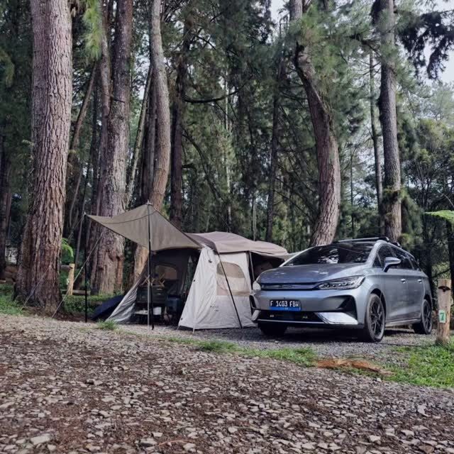 Mobil listrik terparkir di samping tenda