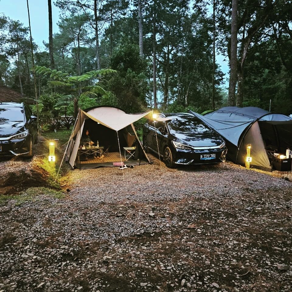 Camp ground dengan tenda dan mobil listrik saat senja